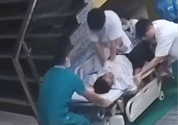 Bác sĩ trẻ ngồi trên băng ca, ép tim cứu bệnh nhân