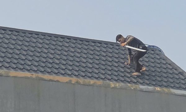 Cảnh sát đang vây bắt hai người cầm kiếm cố thủ trên mái nhà