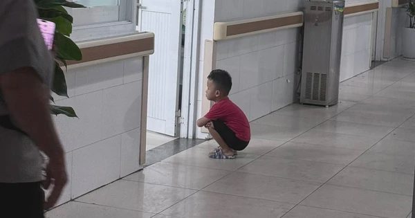 Cậu bé 4 tuổi ngồi xổm ngoài phòng sinh chờ em gái chào đời