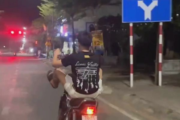 Con lái xe máy bằng chân, bố bị xử phạt
