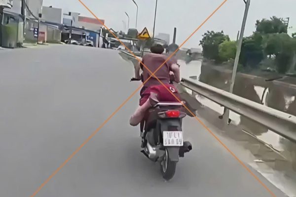 Công an xử lý thanh niên nằm sấp trên yên lái xe máy