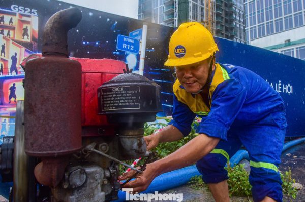 Công nhân dầm mưa bơm nước 'giải cứu' ngập chân cầu Ba Son
