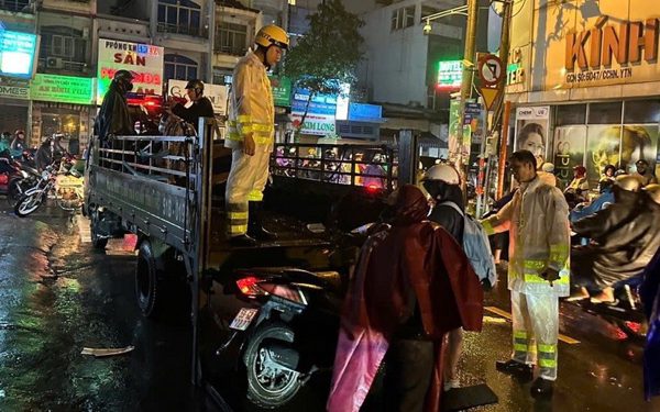 CSGT TP.HCM dầm mưa phân luồng, lội nước giúp dân đưa xe máy qua điểm ngập