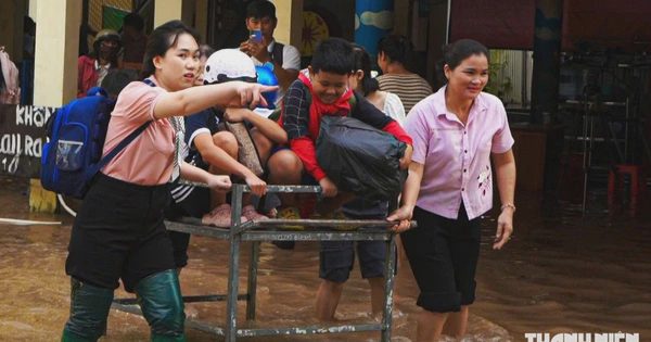 Giáo viên đẩy xe đưa học sinh qua vùng ngập