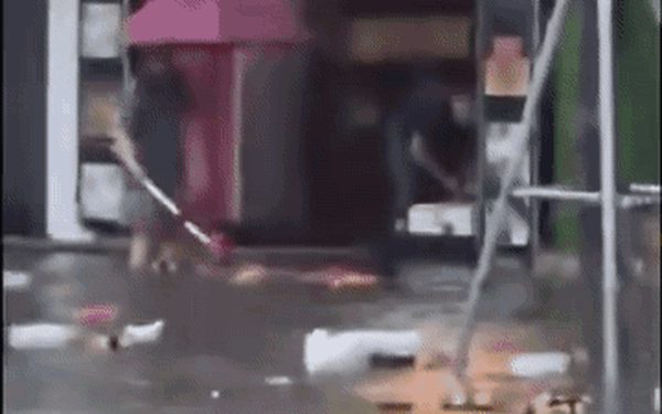 Hai người đẩy rác ra đường giữa lúc Vinh ngập nước