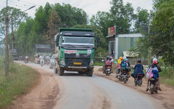 Học sinh nép sát hố bùn trên đường xe tải nối đuôi nhau chạy ngày đêm