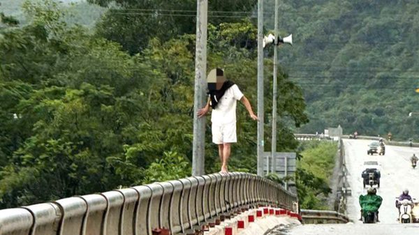 Nam thanh niên ‘làm xiếc’ trên lan can cầu lúc mưa lũ