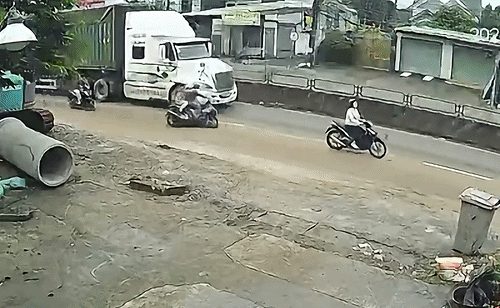 Người đi xe máy đồng loạt ngã, suýt mất mạng cạnh xe container