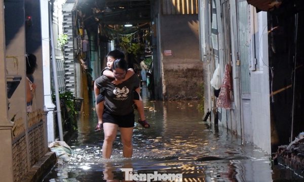 Nước tràn vào nhà, người dân TPHCM tất tả đắp bao cát 'chạy' ngập