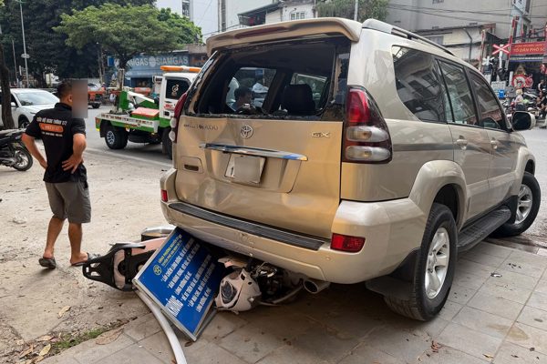 Ô tô Prado lùi trên đường Hà Nội, cuốn xe máy chở 2 phụ nữ vào gầm