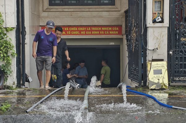 Tầng hầm ngập sâu hơn 1m, người dân ở TPHCM trắng đêm bơm nước dọn bùn