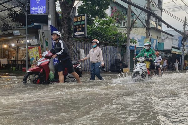 Triều cường dâng cao, người dân TPHCM bì bõm lội nước chiều cuối tuần