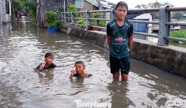 Triều cường dâng cao, trẻ em TPHCM thỏa thích bơi lội trên đường phố