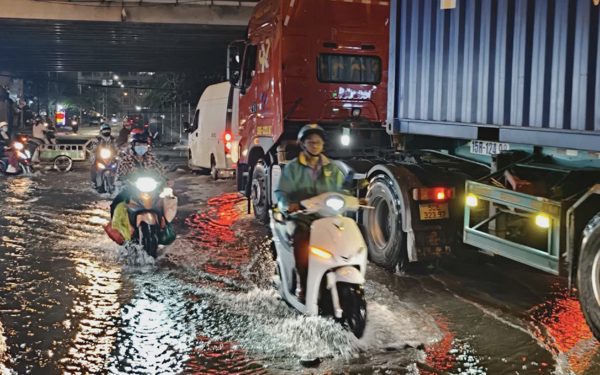 Triều cường dâng, người đi xe máy dò đường tránh ổ gà ở TP.HCM